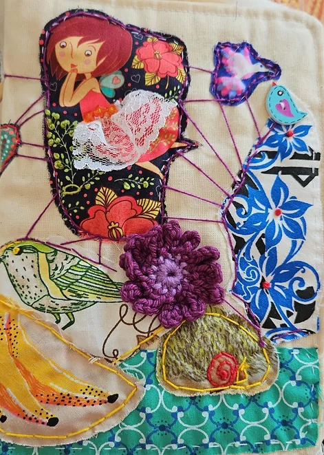 Painel bordado com flores, pássaros e figuras femininas em cores vivas