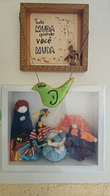 Caixa-moldura com bonecas de pano e um pássaro de feltro